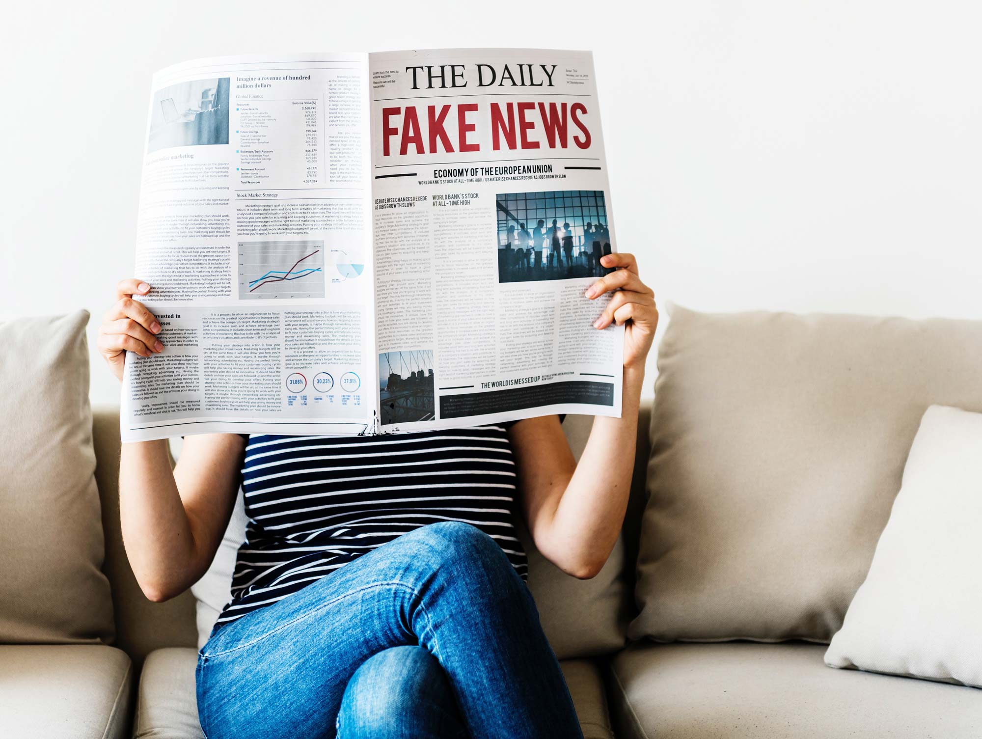 Woman reading newspaper with headline: fake news