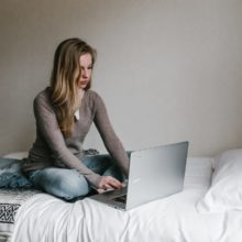 Woman using laptop on bed
