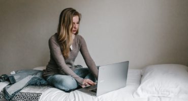 Woman using laptop on bed