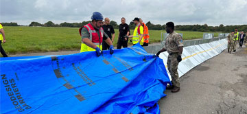 people covering large metal pipeway with tarpaulin