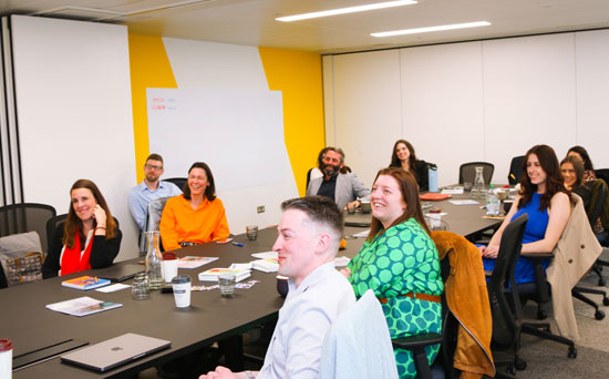 social simulator team sitting around large table smiling