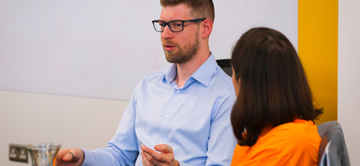 man with glasses talking animatedly