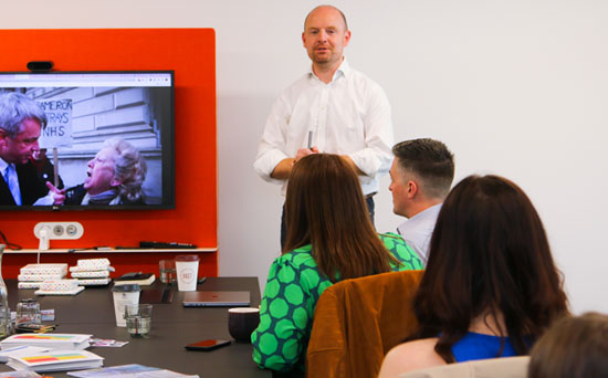 man speaks to small group who listen intently