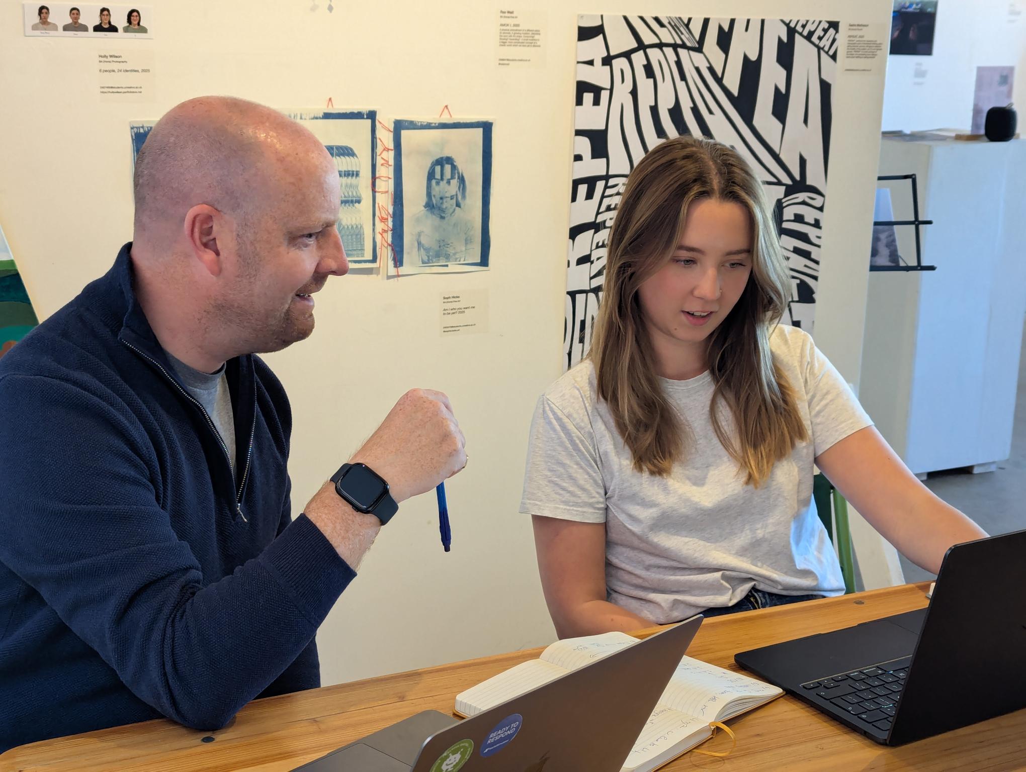A man and woman looking at a screen together