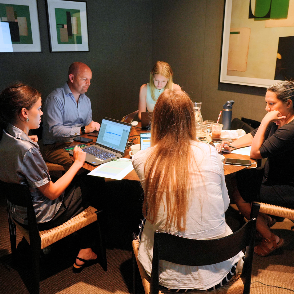 5 people sitting around a round table